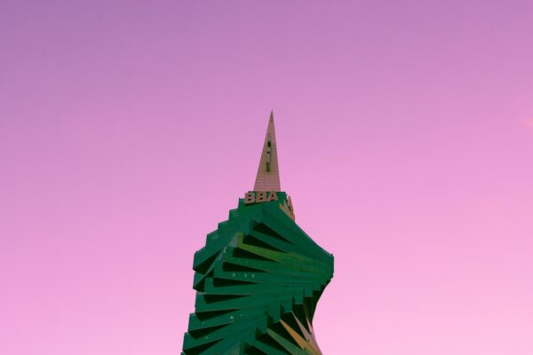 A green building with a pink sky in the background.
