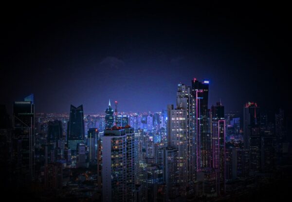 A city skyline with skyscrapers lit up at night.
