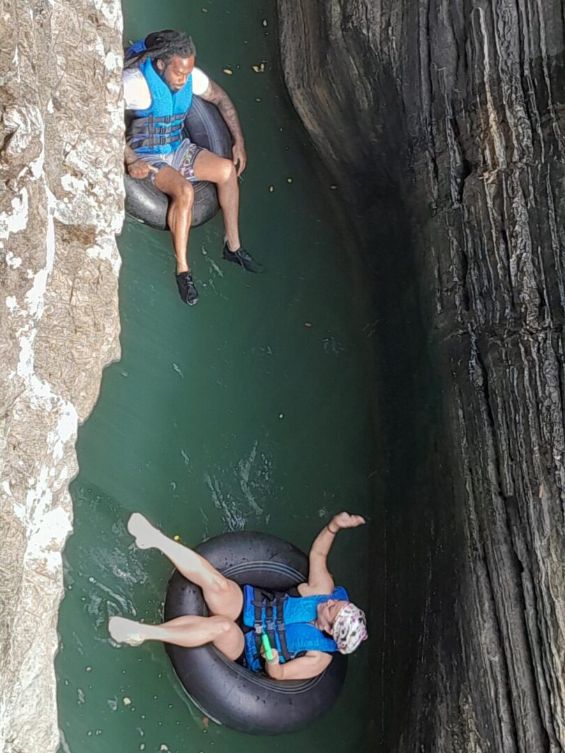 Two people in the water on tubes