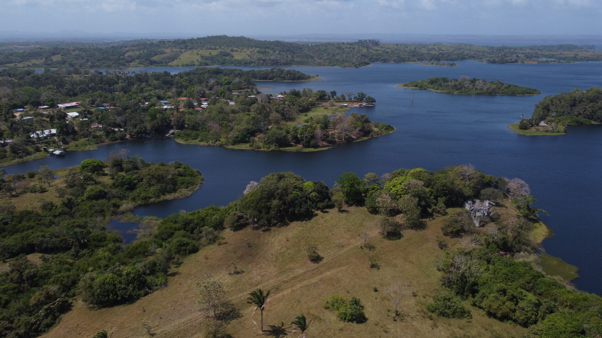 Aerial view of a lush island surrounded by water and greenery.