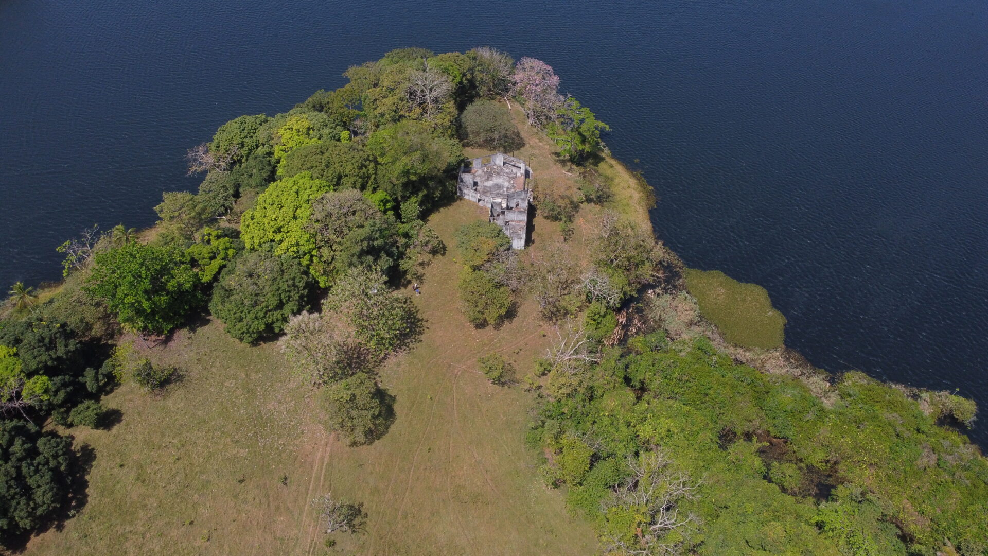 Aerial view of a small island with a stone structure surrounded by water.