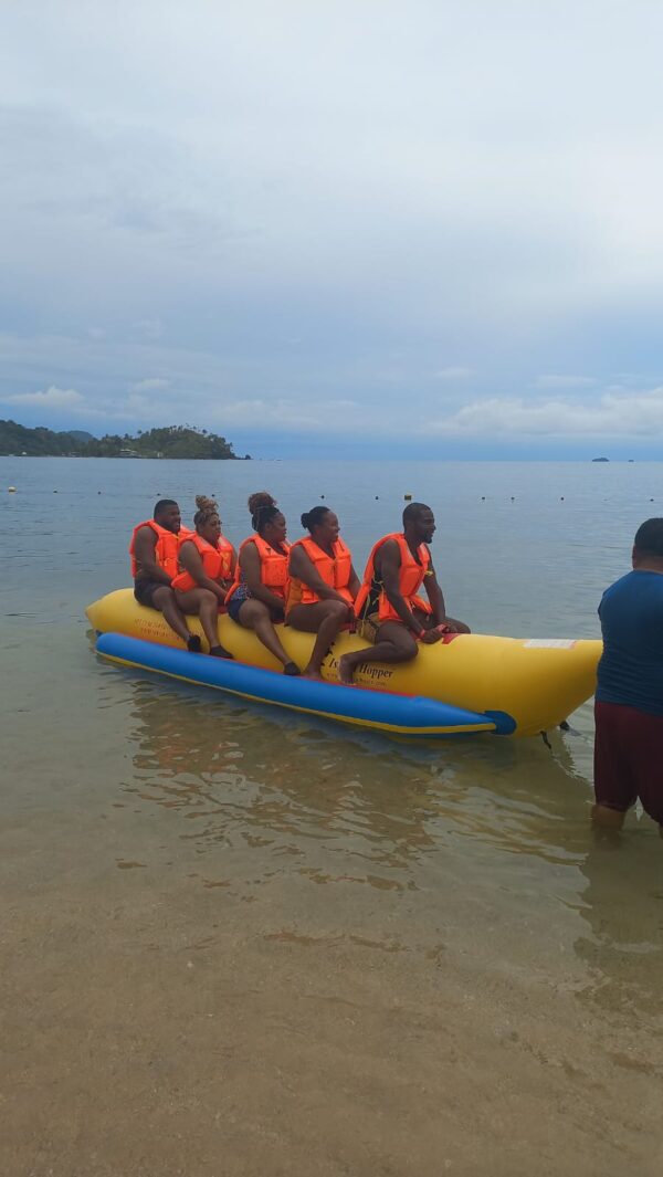 A group of people in life jackets on an inflatable boat.