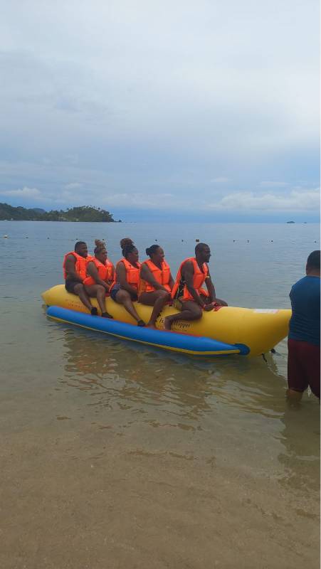 A group of people in life jackets on an inflatable raft.