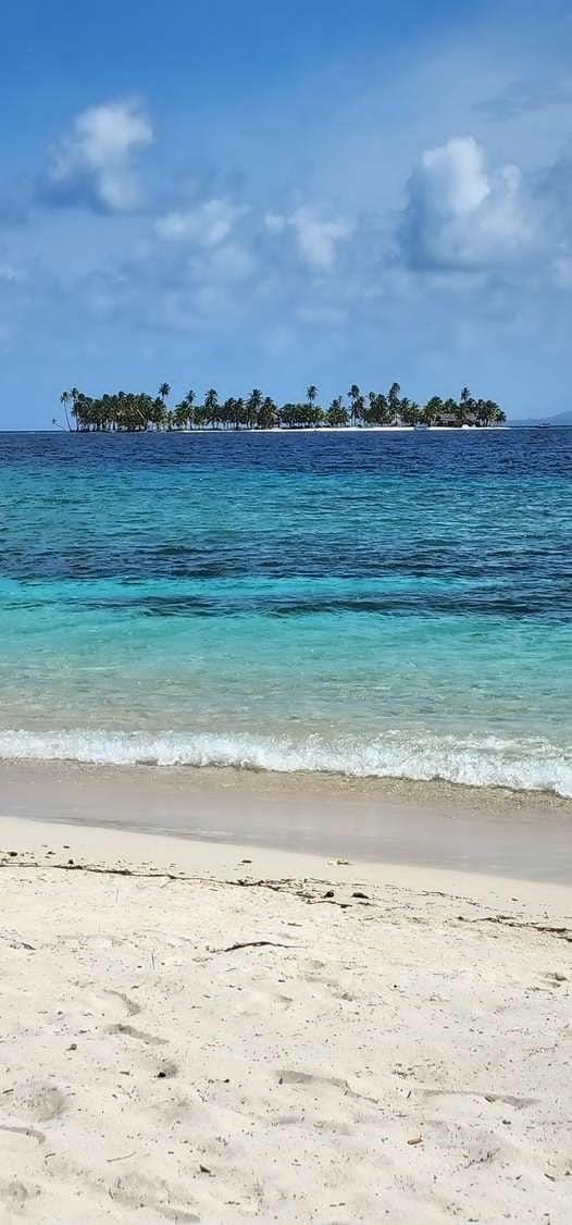 A serene tropical island with clear blue waters and white sandy beach.