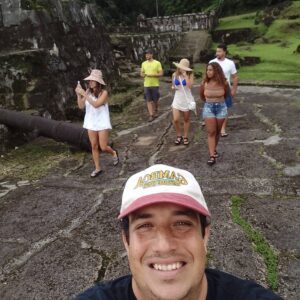 A man taking a selfie with several people in the background.
