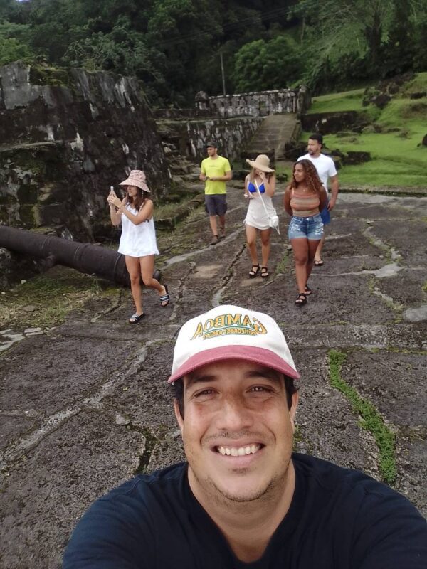 A man taking a selfie with several people in the background.