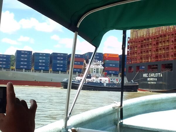 A boat with many containers on it's deck.