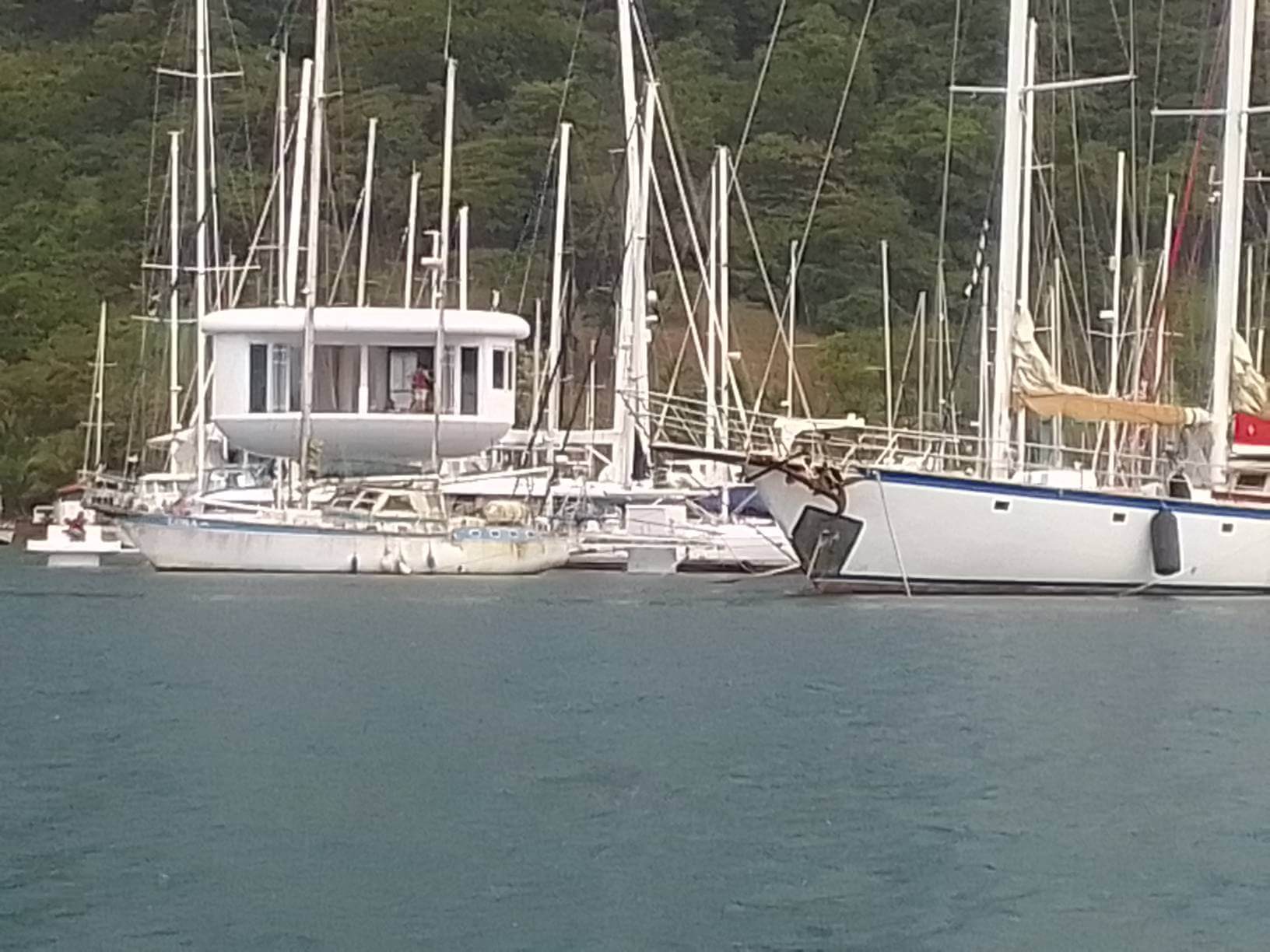 A boat is docked in the water near other boats.