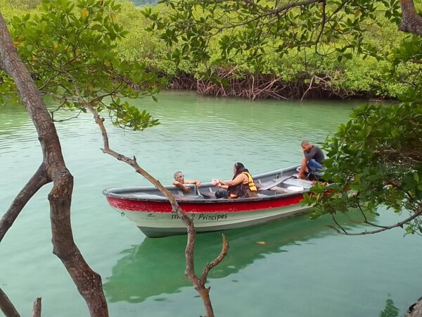 A boat with three people in it on the water.