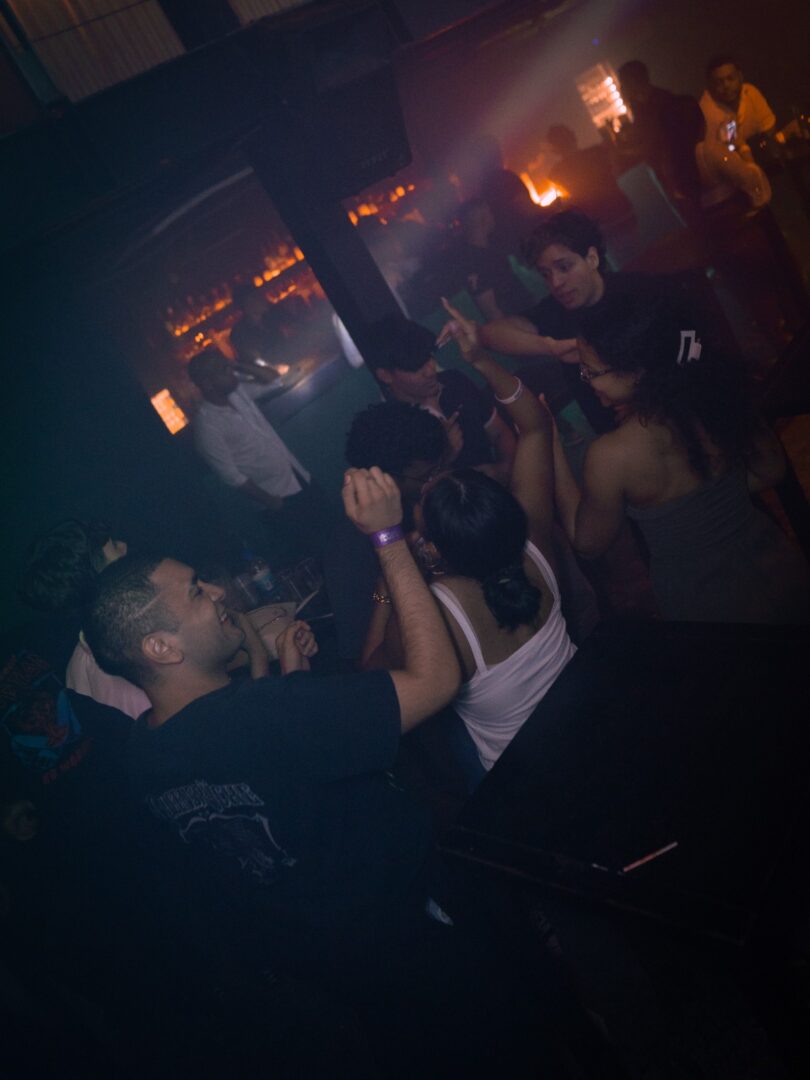 People dancing and enjoying a dimly lit nightclub atmosphere.