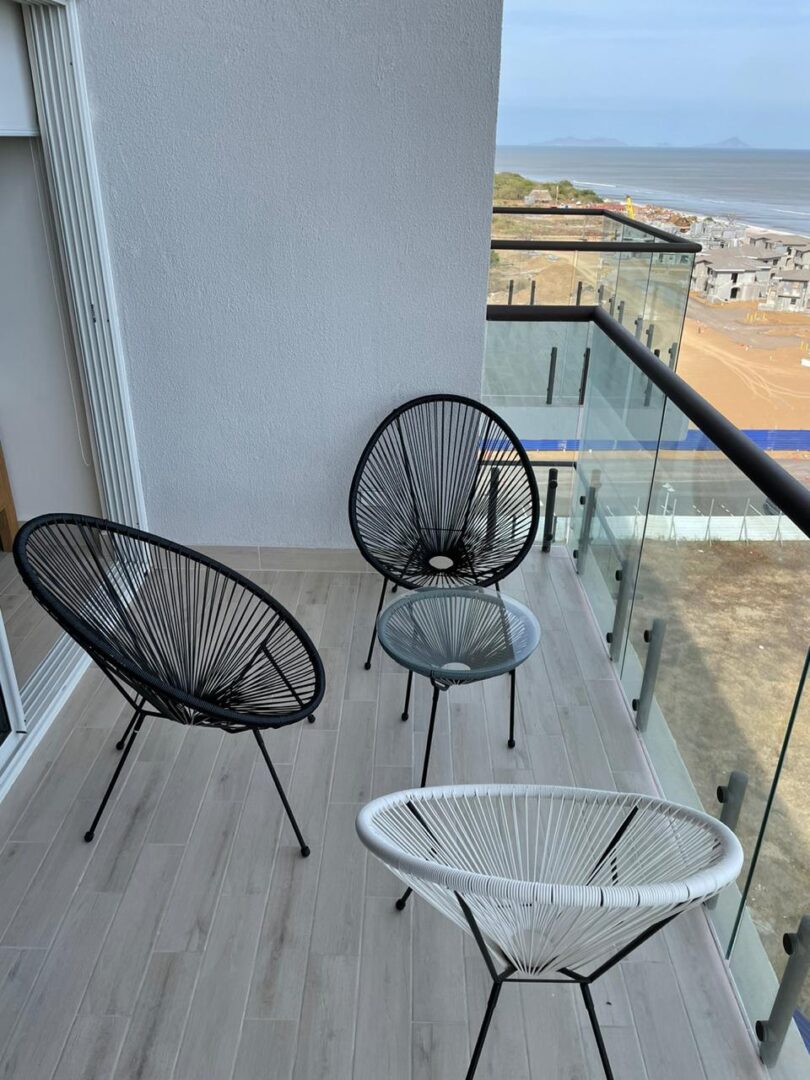 Modern outdoor balcony seating with a sea view.