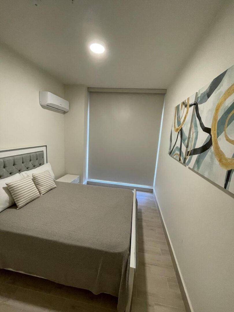 Modern minimalist bedroom with a queen bed and abstract wall art.