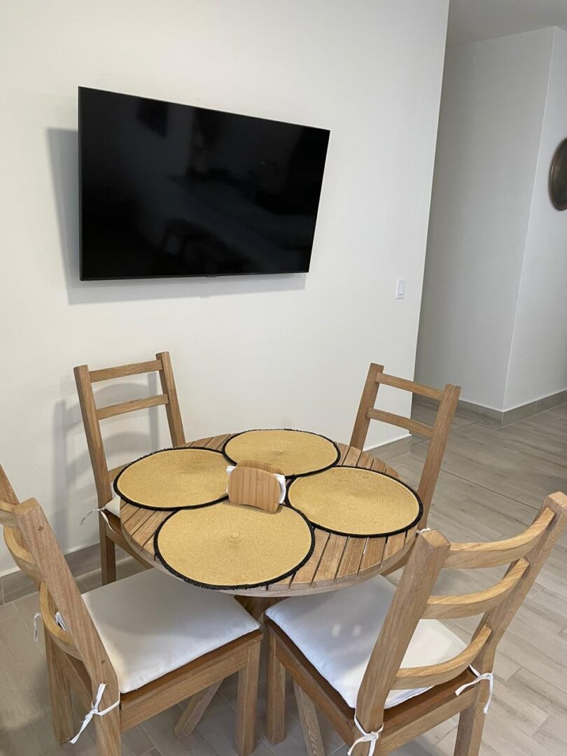 Modern dining area with wooden chairs and a round glass table.