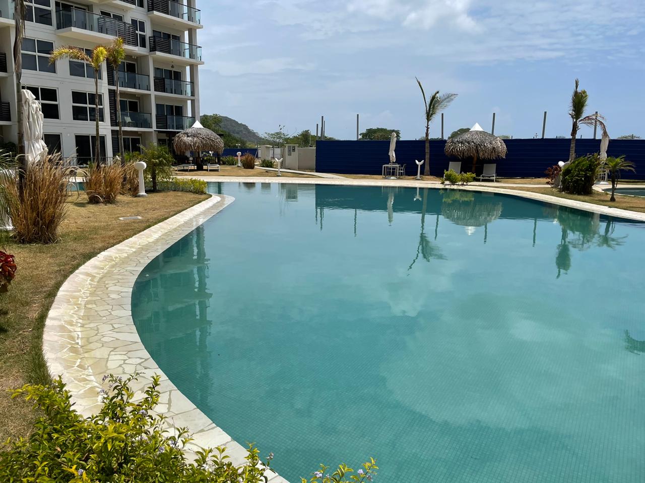 Outdoor swimming pool with clear water beside modern buildings.