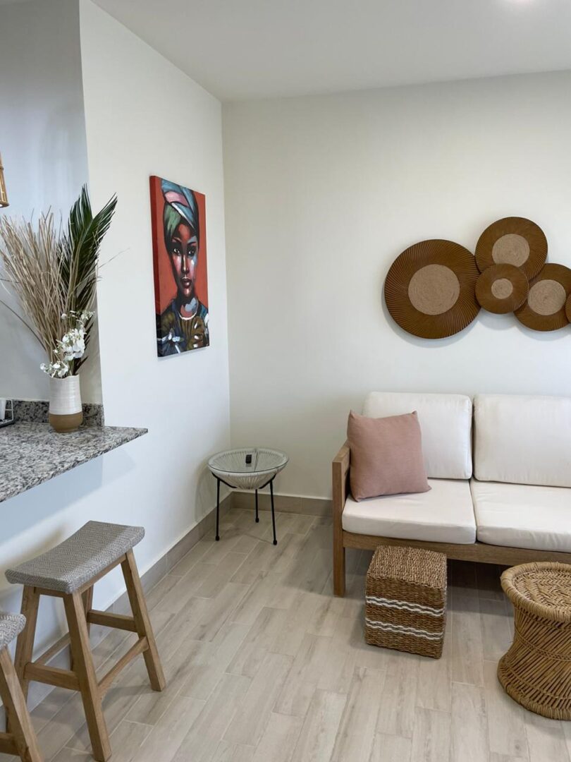 Minimalist living room with white sofa, round wall art, and natural decor.