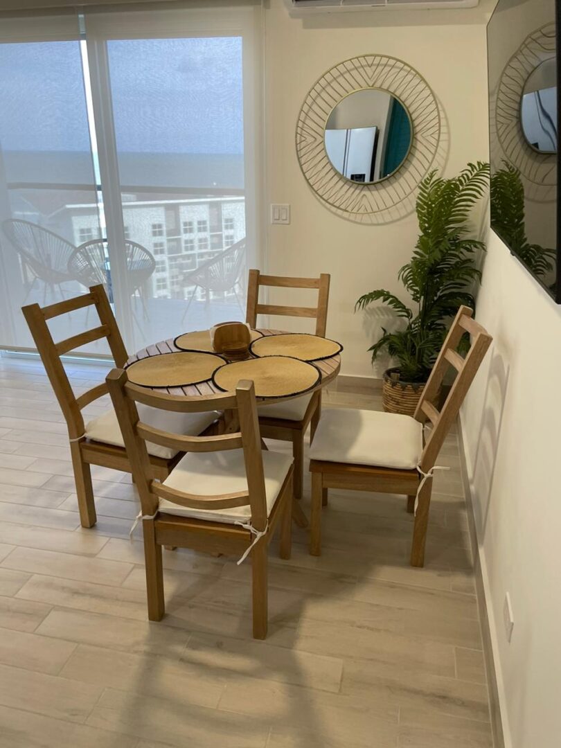 Cozy wooden dining set with four chairs in a bright room.