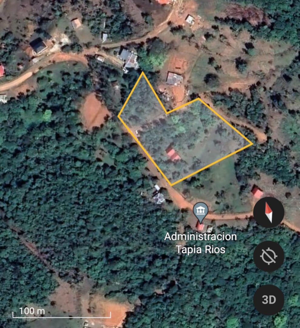 Aerial view of land plots outlined in yellow near a small settlement.