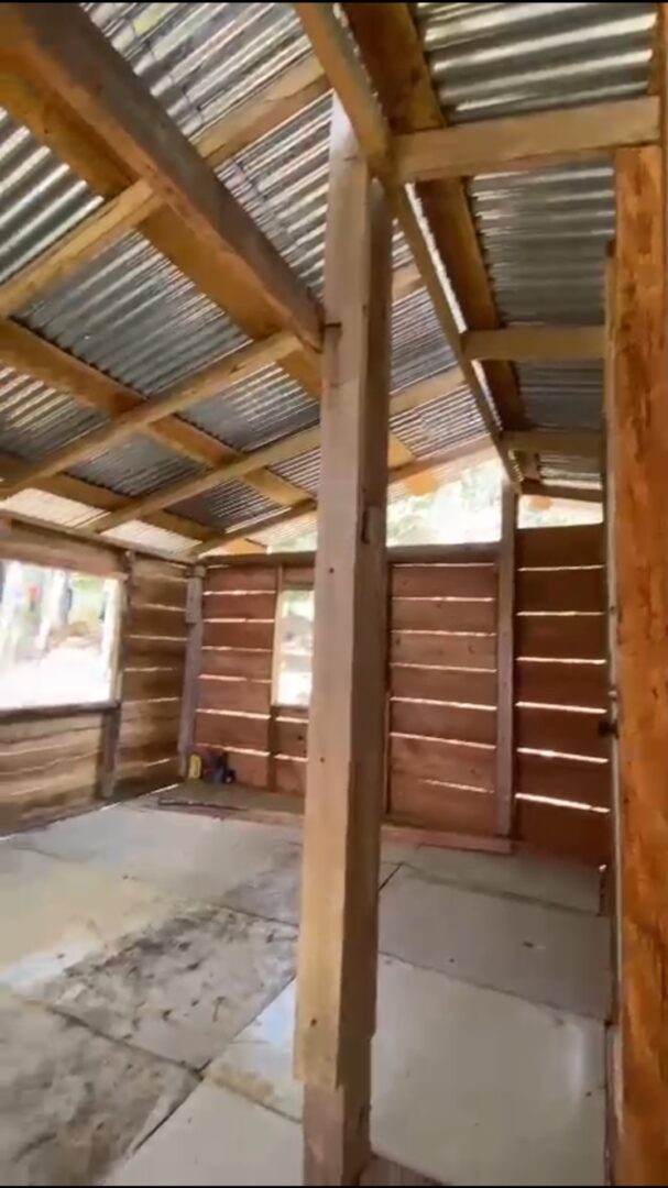 Interior of a rustic wooden shed with corrugated metal roof.